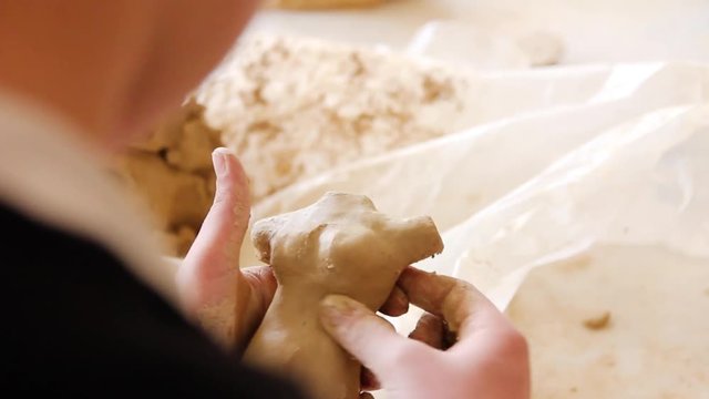 artist sculpts from clay, close-up from detail