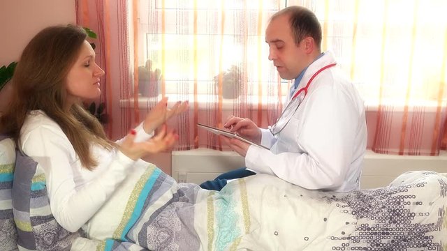 Plastic surgery specialist man consult woman using tablet computer in hospital