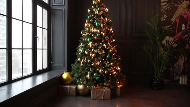 Dark room interior with New Year tree decorated and present boxes