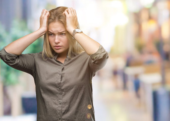 Fototapeta premium Young caucasian business woman over isolated background suffering from headache desperate and stressed because pain and migraine. Hands on head.