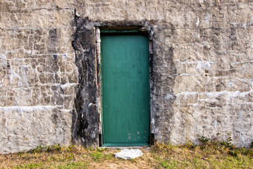 Fototapeta na wymiar Old Green Colored Painted Door on Historic Building