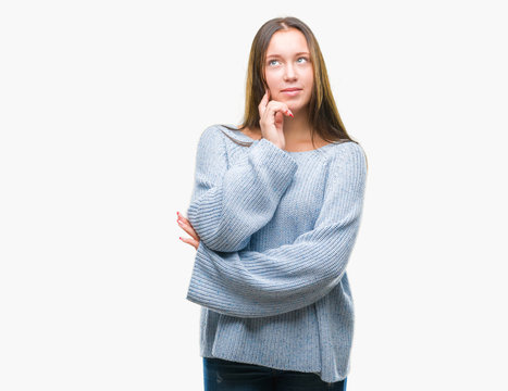 Young beautiful caucasian woman wearing winter sweater over isolated background with hand on chin thinking about question, pensive expression. Smiling with thoughtful face. Doubt concept.