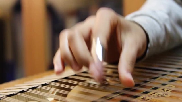 close-up of a hand playing the zither,musical art  
