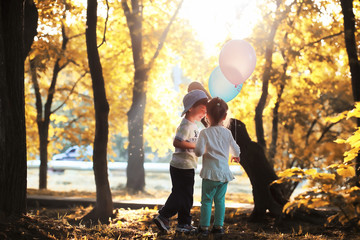 Little children are walking in autumn park