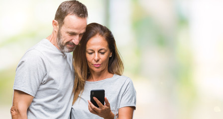 Middle age hispanic couple texting message on smartphone ver isolated background with a confident expression on smart face thinking serious