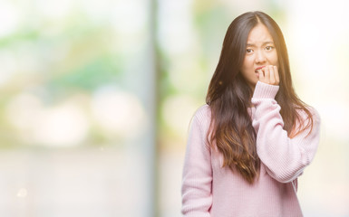 Young asian woman over isolated background looking stressed and nervous with hands on mouth biting nails. Anxiety problem.