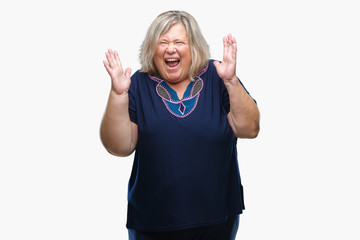 Senior plus size caucasian woman over isolated background crazy and mad shouting and yelling with aggressive expression and arms raised. Frustration concept.