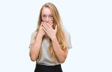 Blonde teenager woman wearing moles shirt shocked covering mouth with hands for mistake. Secret concept.