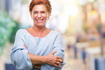 Atrractive senior caucasian redhead woman wearing winter sweater over isolated background happy face smiling with crossed arms looking at the camera. Positive person.