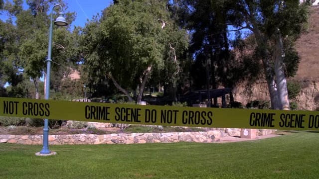CRIME SCENE TAPE AT AN EMPTY PARK, IN 4K