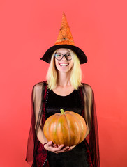 Halloween party. Happy woman in witch costume with magic Pumpkin celebrating Halloween. Beautiful girl in witches hat. Magical witch girl in hat holds pumpkin. Witch hat. Jack-o-lantern. Funny Pumpkin