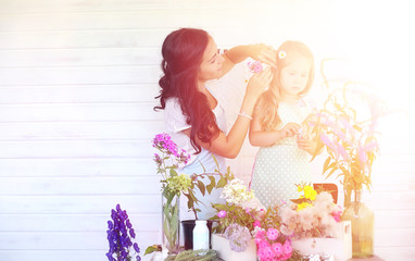 A young girl with a daughter is picking up a bouquet. A young mo