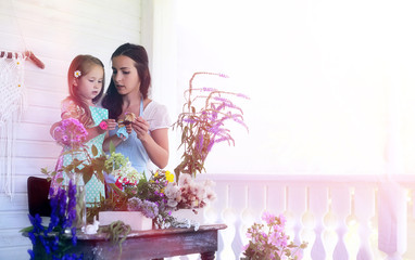 A young girl with a daughter is picking up a bouquet. A young mo