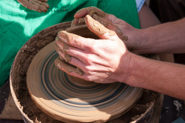 Pottery training, four hands make a pot of clay