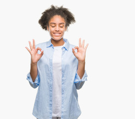 Young afro american woman over isolated background relax and smiling with eyes closed doing meditation gesture with fingers. Yoga concept.