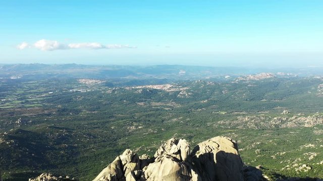 Video from above, aerial view of a beautiful valley surrounded by granite mountains and green vegetation, Monte Limbara, Sardinia, Italy.