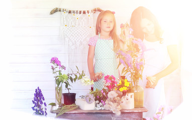 A young girl with a daughter is picking up a bouquet. A young mo
