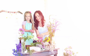 A young girl with a daughter is picking up a bouquet. A young mo