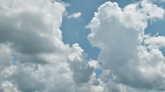 Beautiful cloudscape with large, building clouds and sunrise breaking through cloud mass.