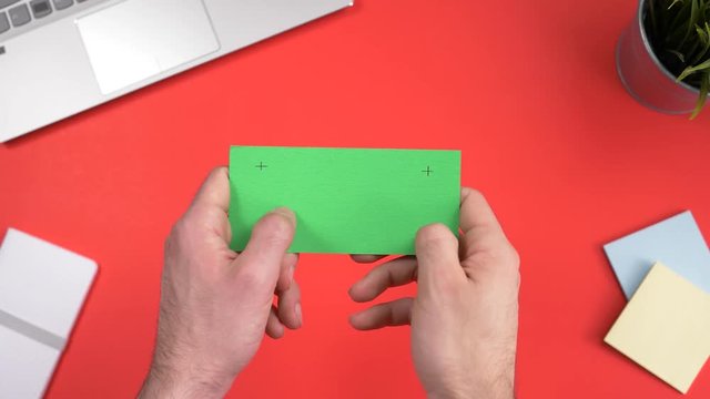 Green screen smartphone being used over a working office desk. Chroma key square screen.