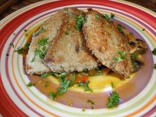 A dish with slices of fish fillet bathed in delicious juicy sauces and flavors