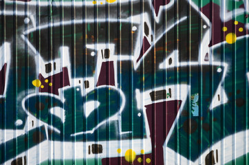 Fragment of graffiti drawings. The old wall decorated with paint stains in the style of street art...