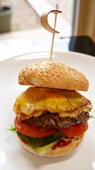 Huge cheeseburger with tomatoes, lettuce, fried egg and pineapple