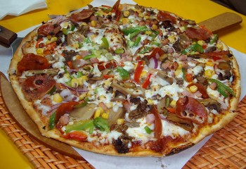 Pizza with thin crust on a wooden serving platter