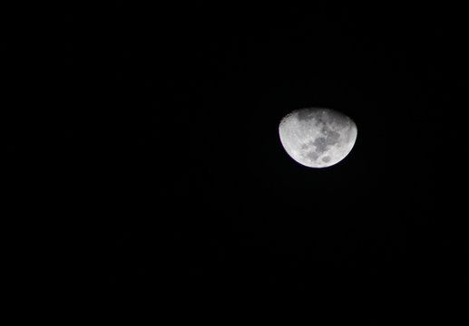 A quarter moon shines against a dark background
