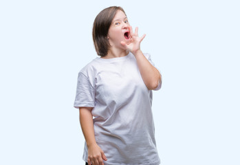 Fototapeta premium Young adult woman with down syndrome over isolated background shouting and screaming loud to side with hand on mouth. Communication concept.