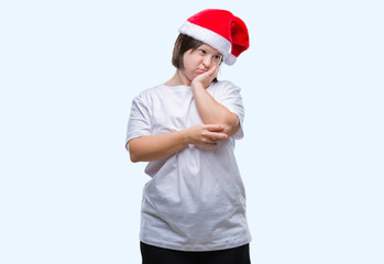 Young adult woman with down syndrome wearing christmas hat over isolated background thinking looking tired and bored with depression problems with crossed arms.