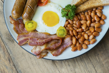 Fried bacon with beans and sausage on the plate