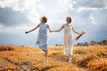 Two girls in dresses in autumn field