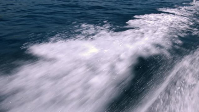 Slow motion - Water splashing at starboard side of the boat on blue ocean sea