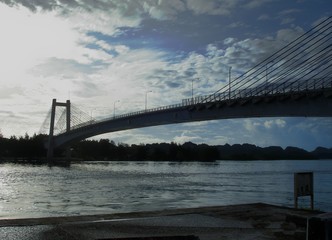 Silhouette of the Japan-Palau Friendship Bridge on a cloudy day, viewed from the Airai State side.