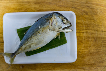 Mackerel in foam box on wooden table