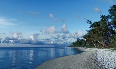Naklejka premium Beautiful beach with white fluffy cottony clouds in Garapan, Saipan, Northern Mariana Islands 
