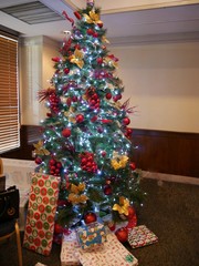 Christmas tree with wrapped gifts, beautifully decorated and lighted