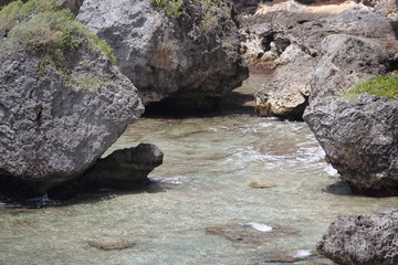 Fototapeta premium Big rocks at a small enclosure where water flows in a tropical beach