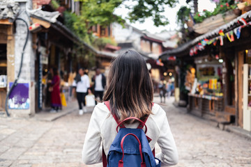 Young woman traveler walking at lijiang old town in Yunnan province, China