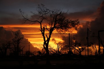 Fiery sunset amid the chaos and devastation left by a typhoon in a tropical island