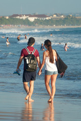 Young loving couple walking on a beach along a sea in their honeymoon