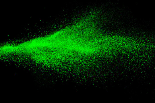 Green color powder explosion cloud  on black background.Green dust splash on dark background.