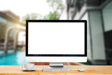 Workspace with computer, keyboard,coffee cup and Mouse with Blank or White Screen Isolated is on the work table at the corner of the pool.