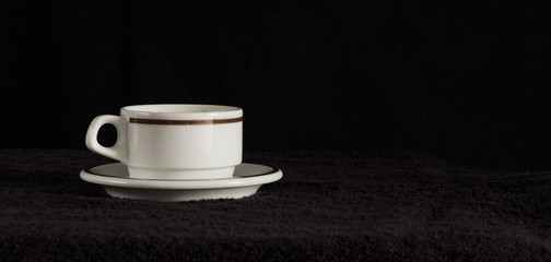  espresso coffee cup - white curved coffee cup with a thin porcelain pale for espresso coffee on a black background, original Italian design