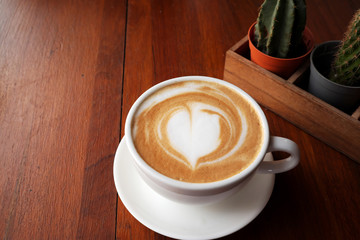 Hot coffee latte on a wooden table.