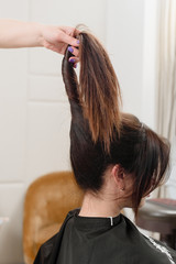 Fototapeta premium Brunette woman doing new hairstyle in professional beauty salon