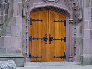 Old wooden heavy doors with antique knockers and door handles of an old church
