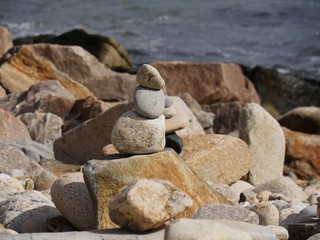 Rocks piled on top of each other by the seaside, with blurred background