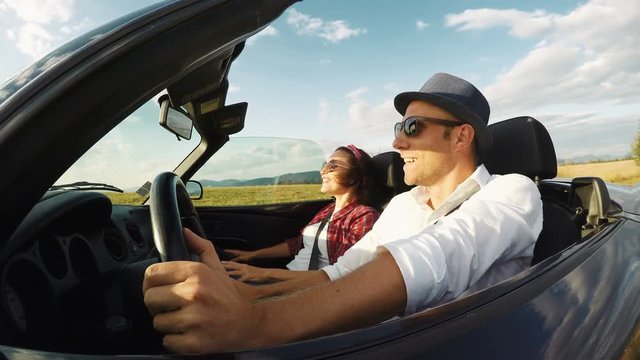 4K footage of a couple driving in the convertible on a sunny day